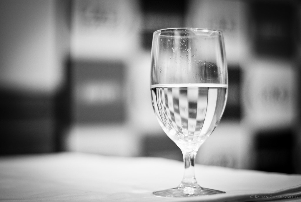 A glass of water with ice on a bar top