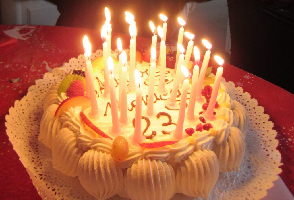 A birthday cake with lit candles on a restaurant table
