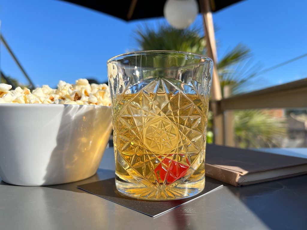 An Old Fashioned cocktail with ice and an orange twist