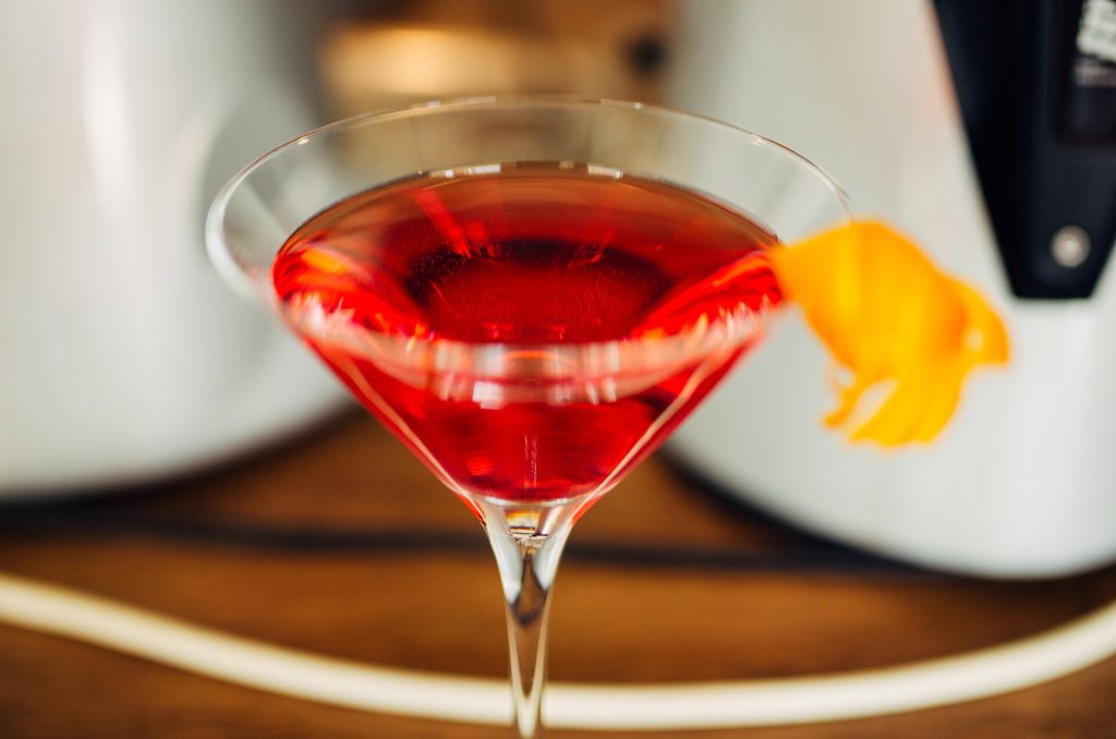 A twist of orange peel over a cocktail glass