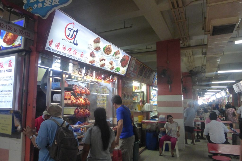A busy street food stall with dishes cooking