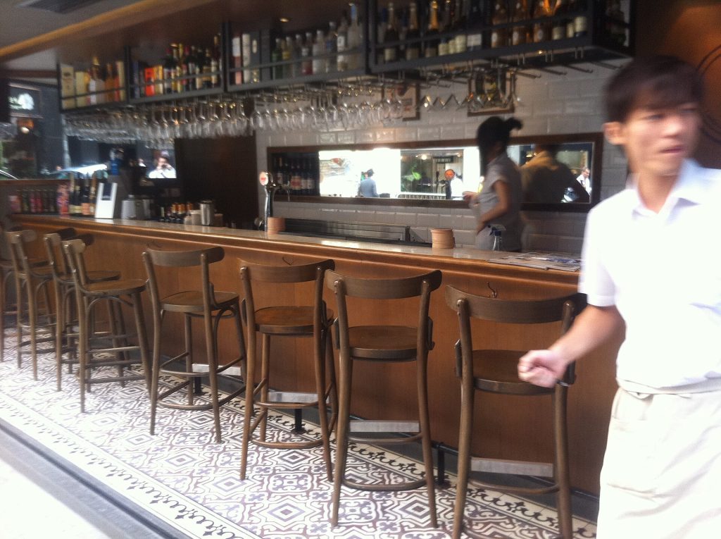 A row of empty bar stools at a restaurant bar before service