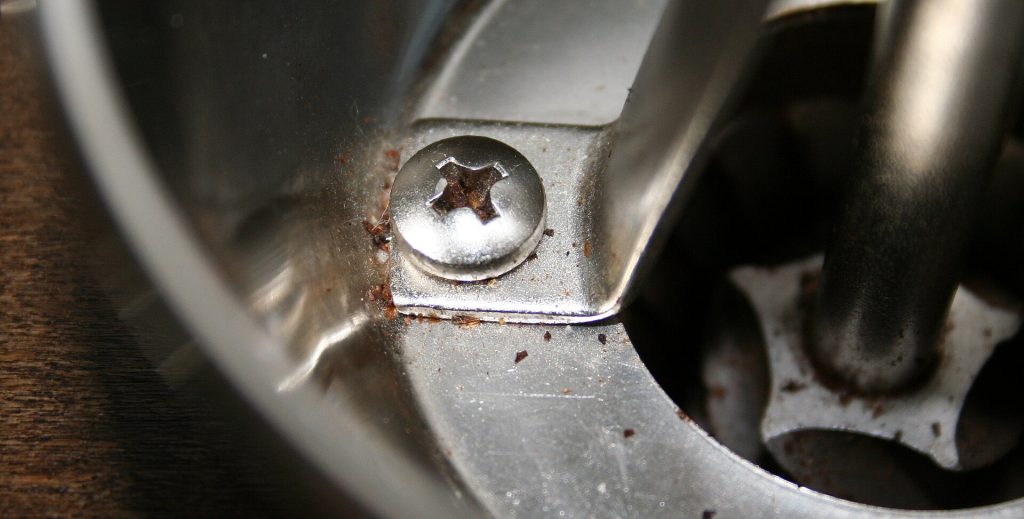 A burr coffee grinder with whole beans in the hopper