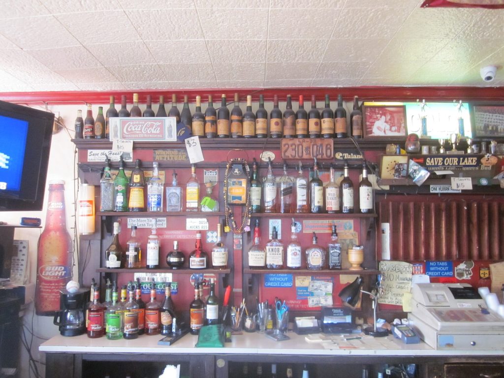 Rows of whisky bottles on shelves behind a bar