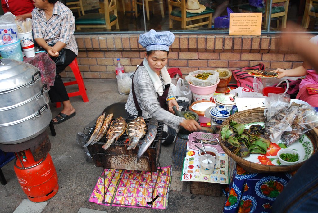 Food cooking on a hot grill at a street food stall