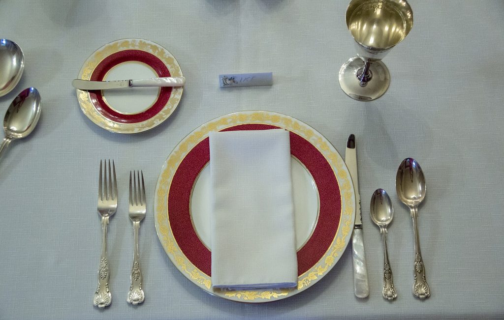 A folded white napkin beside a dinner plate