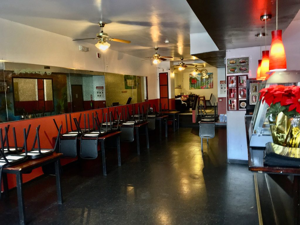 An empty restaurant dining room with set tables before service