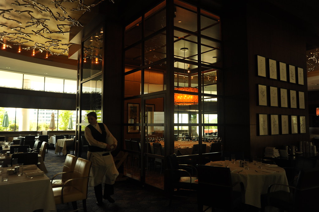 Plates of food being carried across a busy restaurant dining room
