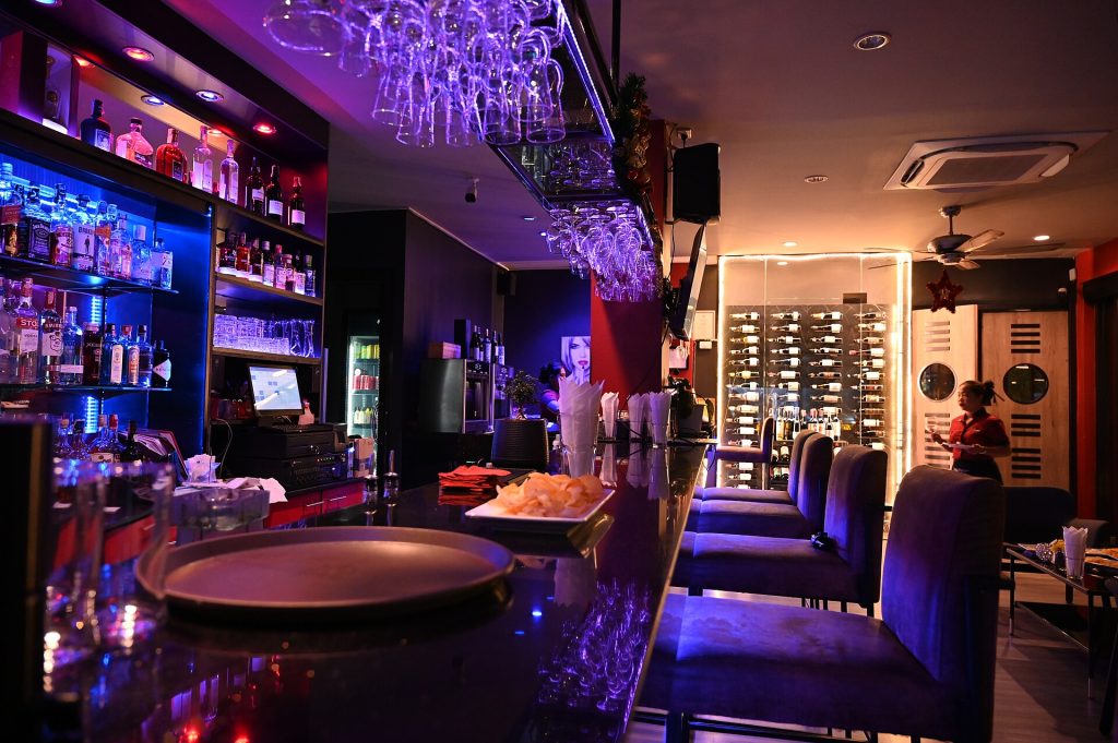A dimly lit cocktail bar with rows of bottles